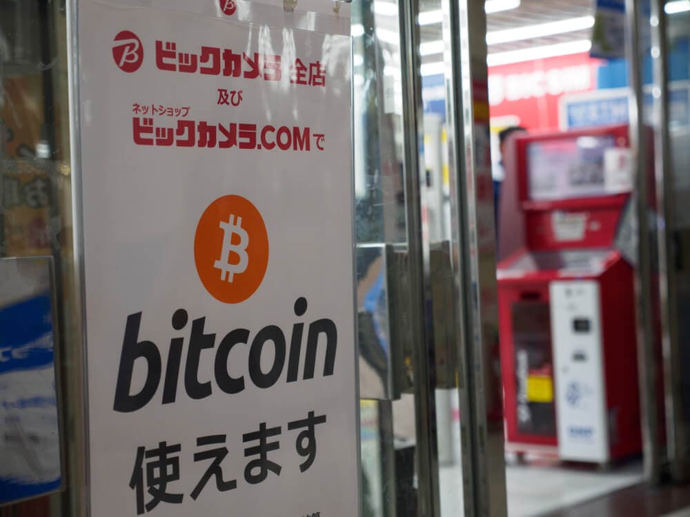 Bitcoin accepted sign on a shop's doors.