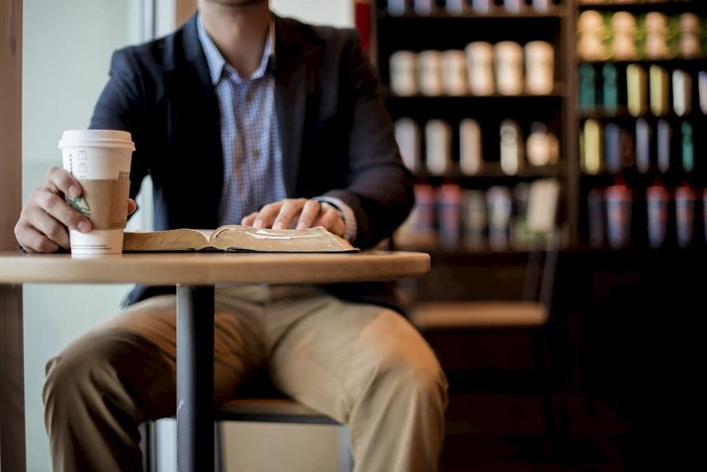 Young entrepreneur reads a book at the cafe.