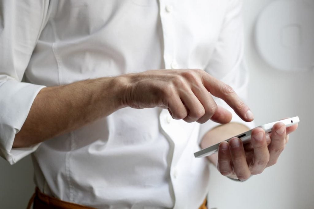 In this photo man holds a smartphone